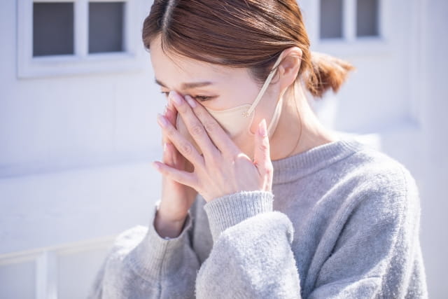 目元を押さえる女性（花粉症のイメージ）